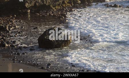 Ätherische Dämmerung, schaumige Wellen, ruhige Küste. Stockfoto