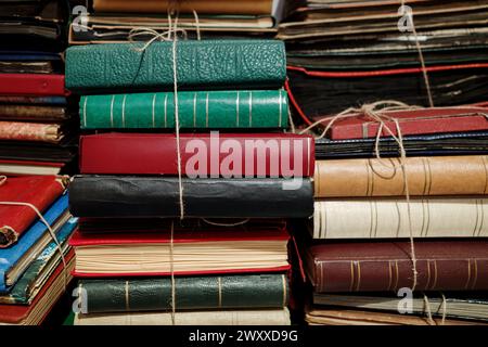 Eine Sammlung alter und abgenutzter Bücher, die mit Garn gebunden sind, in einer willkürlichen Art und Weise gestapelt sind. Stockfoto