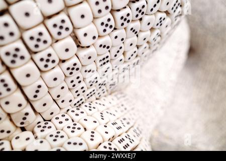 Eine Nahaufnahme einer großen Sammlung von sechsseitigen Würfeln, die ordentlich angeordnet sind und eine Vielzahl von Zahlen auf ihren sichtbaren Gesichtern zeigen. Stockfoto
