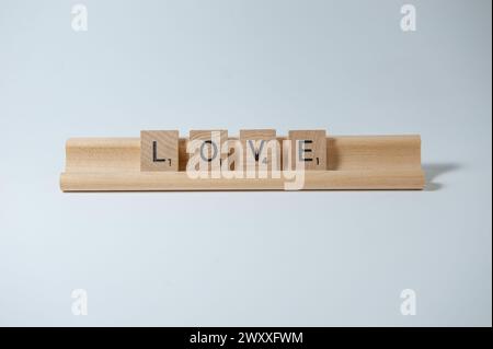 Das Wort LIEBE in Holzfliesen auf einem Holztablett Stockfoto