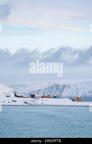 Farbenfrohe Häuser in einer verschneiten Landschaft, Fischerdorf Kongsfjord, Berlevag, Varanger Halbinsel, Finnmark, Nordnorwegen, Norwegen Stockfoto