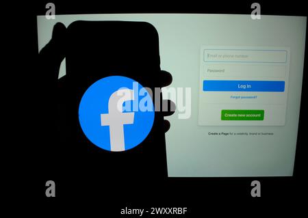 New York, Usa. April 2024. In dieser Abbildung ist das Facebook-Logo auf einem Smartphone-Bildschirm zu sehen, der sich vor der Facebook-Anmeldeseite auf einem Laptop-Bildschirm befindet. Quelle: SOPA Images Limited/Alamy Live News Stockfoto