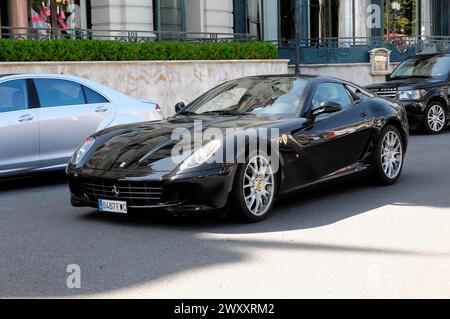 Ein geparkter schwarzer Ferrari in einem städtischen Ort strahlt unter der Sonne, Monte Carlo, Fürstentum Monaco, Monaco Stockfoto