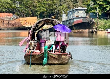 Ayutthaya, Thailand. 31. März 2024. Menschen auf einem Boot auf dem Pa Sak River schützen sich vor der Sonne mit Sonnenschirmen in der Nähe von Ayutthaya. Thailand erlebt derzeit ungewöhnlich hohe Temperaturen von über 40 Grad Celsius. Vermerk: Carola Frentzen/dpa/Alamy Live News Stockfoto