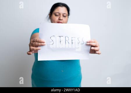 Übergewichtige, fette indianerin, die weiß schreibt, Stress hält. Isoliert über weißem Hintergrund. Plus-Größe weiblich. Stockfoto