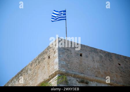 Koules Venezianische Festung am alten Hafen von Heraklion, Ziel der Insel Kreta Griechenland. Griechische winkende Flagge auf Steinmauer berühmtes Denkmal, blauer Himmel Hintergrund. Stockfoto