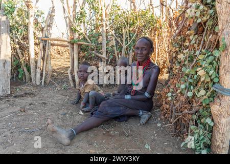 Omorate, Omo Valley, Äthiopien - 11. Mai 2019: Frau aus dem afrikanischen Stamm Dasanesh mit Kindern vor seiner Hütte. Daasanach sind eine kushitische ethnische Gruppe Stockfoto