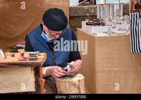 Baiona, Pontevedra, Spanien; 6. März 2022; Goldschmied Handwerker fertigt Armbänder während des Arribada Festivals, das die Ankunft des Karavels feiert Stockfoto