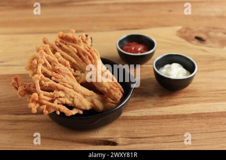 Frittierter knuspriger Enoki-Pilz mit Sauce und Mayonaise auf Holztisch Stockfoto