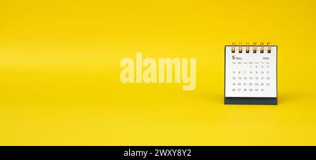 Ein Schreibtischkalender für Mai 2024 auf gelbem Hintergrund. Banner. Leerzeichen für Text Stockfoto