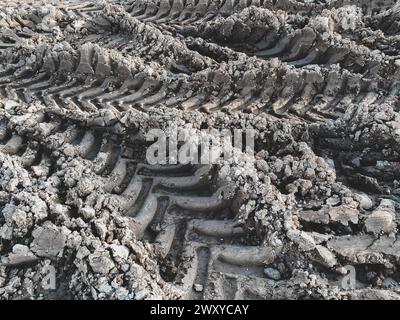 Markierungen von Tiefprofilreifen, selektiver Fokus. Hintergründe der Reifenspuren im Schlamm. Baustellenkonzept Stockfoto