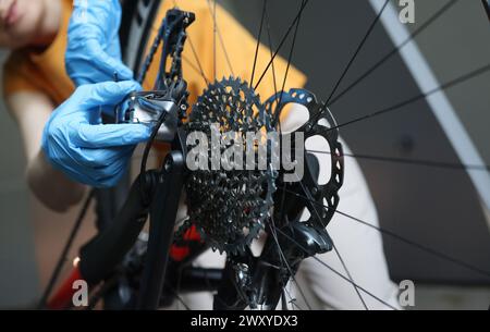 Handwerker in Gummi-Schutzhandschuhen Reparatur Fahrrad Nahaufnahme Stockfoto