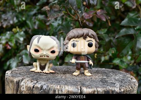 Funko Pop Actionfiguren von Gollum und Hobbit Frodo aus dem Fantasy-Film der Herr der Ringe. Dunkler Wald, Baumstumpf. Stockfoto