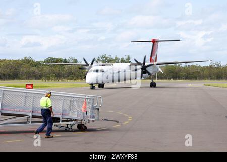 Flughafenpersonal bereitet mobile Treppen für das ankommende QantasLink Dash 8 regionale Turboprop-Flugzeug am Hervey Bay Airport, Queensland, Australi vor Stockfoto