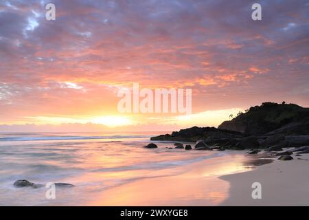 Wunderschöner Sonnenaufgang am Cabarita Beach, NSW, Australien mit der Silhouette von Norries Head am Himmel. Stockfoto