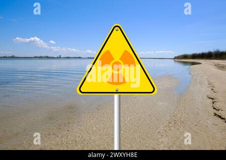 Radioaktive Verschmutzung. Warnschild mit Gefahrensymbol in der Nähe des Meeres Stockfoto