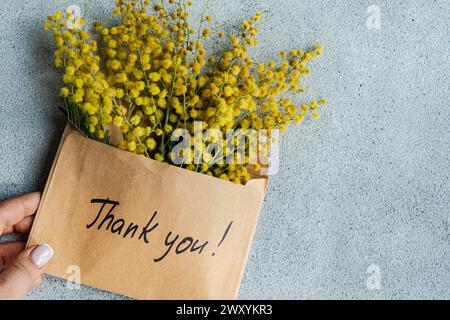 Dankeschön! Geschrieben, begleitet von gelben Mimosa-Blüten. Stockfoto