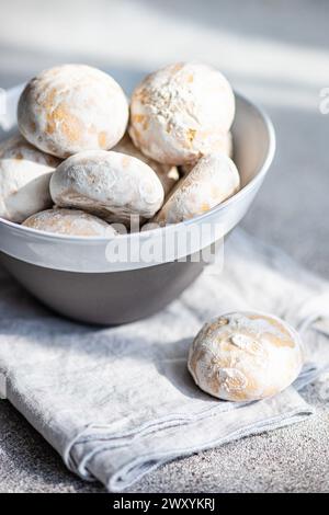 Eine Schüssel gefüllt mit frischen, mit Puderzucker bestäubten Keksen auf einem strukturierten Tuch Stockfoto