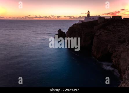 Ein ruhiger Sonnenuntergang, der ein sanftes Leuchten auf der Cape St. ausstrahlt Der Leuchtturm von Vincent befindet sich auf zerklüfteten Klippen vor einer ruhigen Kulisse des Ozeans. Stockfoto