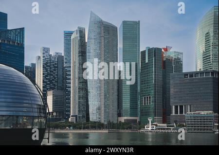Moderne Wolkenkratzer dominieren die Skyline über einem urbanen Ufergebiet und zeigen die Verschmelzung von Architektur und Wasserstraße Stockfoto