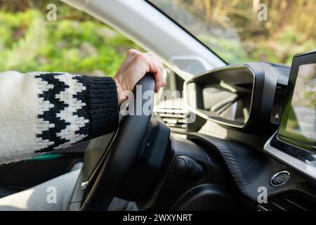 Nahaufnahme einer Person, die das Lenkrad in einem modernen Auto hält Stockfoto