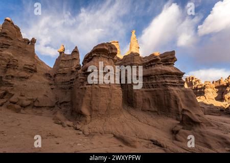 Majestätische Sandsteinformationen, die an Kobolde erinnern, stehen unter einem dynamischen Himmel im Goblin Valley State Park in Utah. Stockfoto