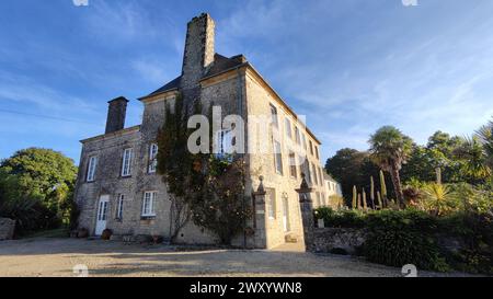 Wunderschönes rustikales Stadthaus in Frankreich. Es ist ein Privathaus mit ziemlich alter Steinarchitektur. An der Fassade gibt es Weinstöcke und weiße Holzfenster Stockfoto