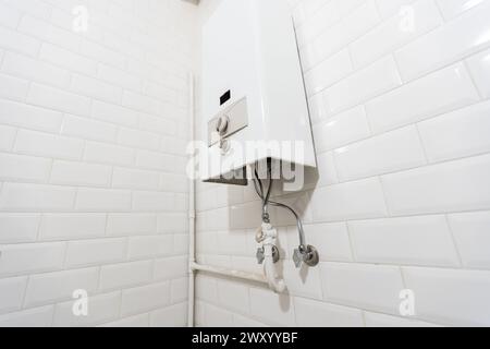 Gebrochene moderne Wasser Gas-Heizung neben Dusche Kabine innen elegante saubere Badezimmer Innenraum. Stockfoto