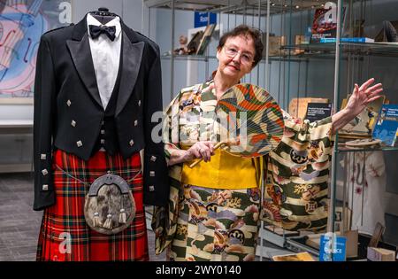 Central Library, Edinburgh, Schottland, Vereinigtes Königreich, 03. April 2024, die Ausstellung „Tanz um die Welt“ des Traditional Dance Forum of Scotland und des Edinburgh City Libraries for Granatapfeles Festival wird heute eröffnet und präsentiert Gegenstände aus über 20 Ländern. Im Bild: Der schottische Tanzkünstler und Historiker Agnes Ness (81 Jahre alt), der die Ausstellung mitkuratierte, mit einem kompletten Highland-Tanzoutfit, das seit 1978 bei Scottish Country Dance Society von einem lebenslangen Mitglied der Royal Scottish Country Dance Society vor der Ausstellung getragen wird. Quelle: Sally Anderson/Alamy Live News Stockfoto