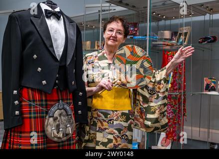 Central Library, Edinburgh, Schottland, Vereinigtes Königreich, 03. April 2024, die Ausstellung „Tanz um die Welt“ des Traditional Dance Forum of Scotland und des Edinburgh City Libraries for Granatapfeles Festival wird heute eröffnet und präsentiert Gegenstände aus über 20 Ländern. Im Bild: Der schottische Tanzkünstler und Historiker Agnes Ness (81 Jahre alt), der die Ausstellung mitkuratierte, mit einem kompletten Highland-Tanzoutfit, das seit 1978 bei Scottish Country Dance Society von einem lebenslangen Mitglied der Royal Scottish Country Dance Society vor der Ausstellung getragen wird. Quelle: Sally Anderson/Alamy Live News Stockfoto