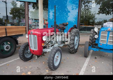 Vorderansicht eines alten roten Traktors, der auf der Straße geparkt ist. Es handelt sich um einen Massey Ferguson Modell 35 Stockfoto