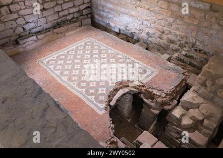 Westbadehaus in der Chedworth Roman Villa mit einem Hypokaukasus und kleinen Backsteinsäulen (Pilae), die einen Mosaikboden im Tepidarium (warmes Zimmer), Großbritannien, stützen Stockfoto