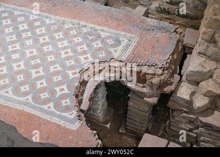 Westbadehaus in der Chedworth Roman Villa mit einem Hypokaukasus und kleinen Backsteinsäulen (Pilae), die einen Mosaikboden im Tepidarium (warmes Zimmer), Großbritannien, stützen Stockfoto