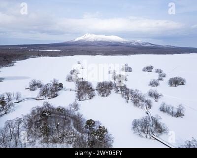See Onuma, Japan: Luftaufnahme des gefrorenen Sees Onuma mit dem Komagatake-Vulkan im Hintergrund bei Hakodate in Hokkaido im Winter in Japan Stockfoto