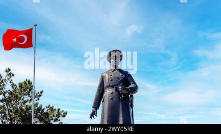 Statue von Atatürk mit türkischer Flagge, die vor einem klaren blauen Himmel winkt. Ezrurum, Türkei - August 2023. Stockfoto