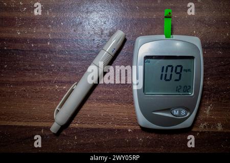 Ein Glukometer und ein Lanzettenstift, Blutzuckertest, Blutzuckermessung Bluttest. Stockfoto