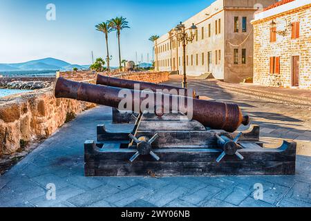 Alte stillgelegte Kanonen auf den historischen Stadtmauern von Alghero, berühmtes Zentrum und Ferienort im Nordwesten Sardiniens, Italien Stockfoto