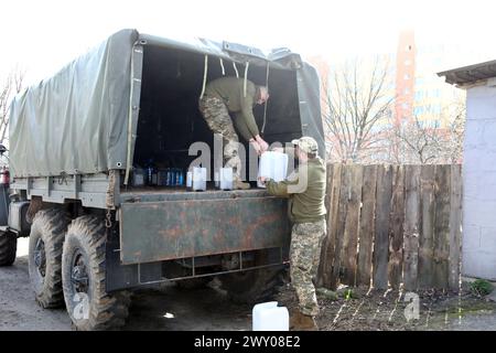 KIEW REGION, UKRAINE - 02. APRIL 2024 - während der Veranstaltung anlässlich des zweiten Jahrestages der Befreiung der Region Kiew von russischen Besatzern laden Soldaten Kanister in ein Fahrzeug auf dem Gelände der Stiftung Safe Region in Vyschneve, Kiew Region, Nord-Ukraine. Stockfoto
