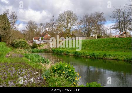 The Mill House in malerischer Lage neben einem Fluss und Teich im frühen Frühjahr in Nutbourne nahe Pulborough im ländlichen West Sussex, England. Stockfoto