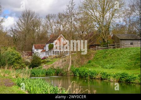 The Mill House in malerischer Lage neben einem Fluss und Teich im frühen Frühjahr in Nutbourne nahe Pulborough im ländlichen West Sussex, England. Stockfoto