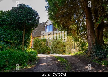 Das Old School House (1848) wurde heute an einem sonnigen Frühlingstag in einem Dorf in Nutbourne nahe Pulborough in West Sussex, England, zu einem privaten Haus umgebaut. Stockfoto