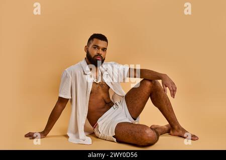 Ein Mann mit Bart sitzt auf dem Boden, tief in Gedanken und Reflexion, umgeben von einer friedlichen Atmosphäre. Stockfoto