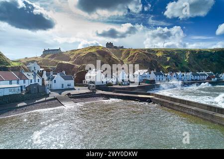 Pennan Village Aberdeenshire Schottland der kleine Hafen und weiße Häuser mit Sprühnebel auf dem Wellenbrecher bei Flut Stockfoto