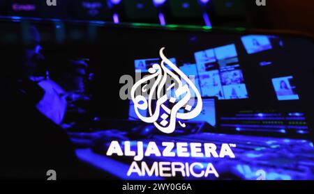 Viersen, Deutschland - 1. April. 2024: Smartphone-Bildschirm auf Computertastatur mit Logo-Schriftzug von Al Jazeera arab Television america Stockfoto