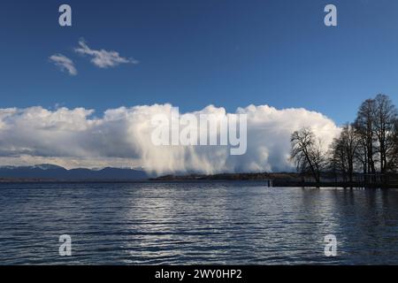 Tutzing, Bayern, Deutschland 02. April 2024: Ein Frühlingstag in Tutzing Landkreis Starnberg. Hier der Blick über den Starnberger See auf eine Regenfront, Regenwand, Regenvorhang, Naturschauspiel, Niederschlag, Wolken die von der Sonne angestrahlt werden, im Hintergrund die Alpenkette mit dem Karwendel, Wetterbild , ausregnen *** Tutzing, Bayern, Deutschland 02 April 2024 Ein Frühlingstag im Stadtteil Tutzing Starnberg hier der Blick über den Starnberger See zu einer Regenfront, Regenwand, Regenvorhang, Naturschauspiel, Niederschlag, Wolken, die von der Sonne beleuchtet werden, im Hintergrund die Alpenkette mit dem Ka Stockfoto