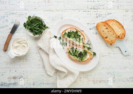 Toast oder Sandwich mit Frischkäse, Mikrogemüse, Erbsen und Sonnenblumen. Konzept gesunde Lebensmittel oder Snack. Flache Ladefläche, Kopierraum. Stockfoto