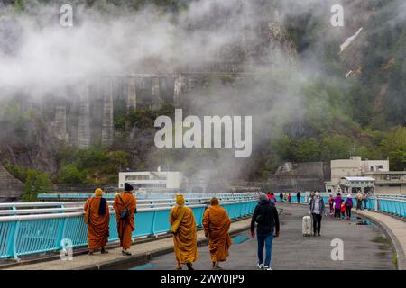 KUROBE-STAUDAMM, JAPAN - 26. MAI 2023: Touristen trotzen stürmischem Himmel und Regen auf dem Kurobe-Staudamm, Japans höchstem Staudamm. Stockfoto