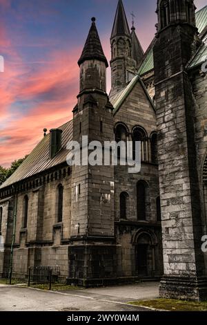 Nidaros Kathedrale Kapitelhaus Sakristei mit Türmen in der Abenddämmerung, rosa roter Himmel über Türmen. Touristenziel in Trondheim Norwegen Stockfoto