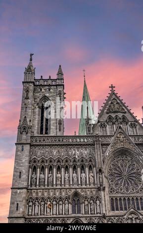 Sonnenuntergang über der Fassade der Nidaros Kathedrale Glockenturm und Turm. Die Fassade der Kathedrale hebt sich von einem lebhaften Sommerabendhimmel in Trondheim Norwegen ab Stockfoto