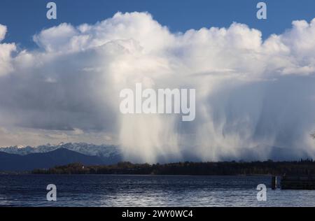 Tutzing, Bayern, Deutschland 02. April 2024: Ein Frühlingstag in Tutzing Landkreis Starnberg. Hier der Blick über den Starnberger See auf eine Regenfront, Regenwand, Regenvorhang, Naturschauspiel, Niederschlag, Wolken die von der Sonne angestrahlt werden, im Hintergrund die Alpenkette mit dem Karwendel, Wetterbild, ausregnen *** Tutzing, Bayern, Deutschland 02 April 2024 Ein Frühlingstag im Stadtteil Tutzing Starnberg hier der Blick über den Starnberger See zu einer Regenfront, Regenwand, Regenvorhang, Naturschauspiel, Niederschlag, Wolken, die von der Sonne beleuchtet werden, im Hintergrund die Alpenkette mit dem Kar Stockfoto